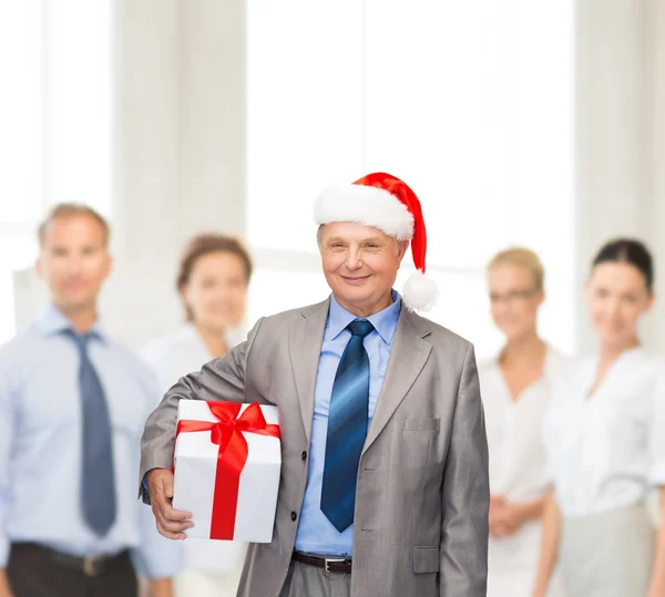 Smiling man in suit and santa helper hat with gift — Stock Photo, Image