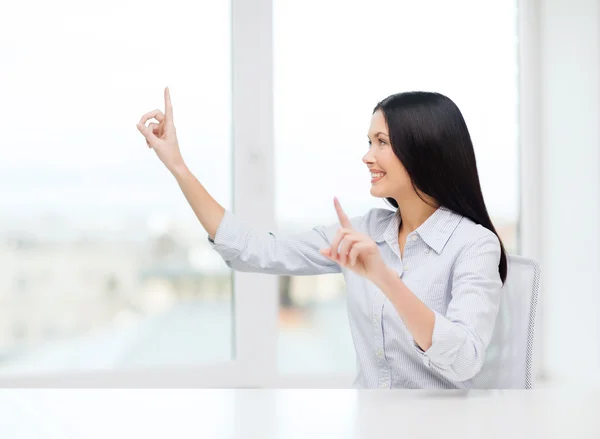 Mulher sorridente apontando para algo imaginário — Fotografia de Stock