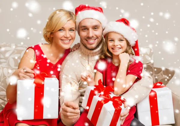 Lächelnde Familie mit Geschenkschachteln und Funkeln — Stockfoto