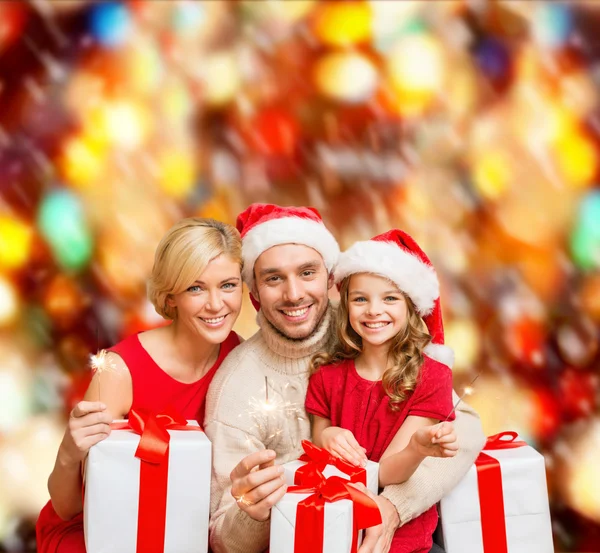 Sorrindo família segurando caixas de presente e brilhos — Fotografia de Stock