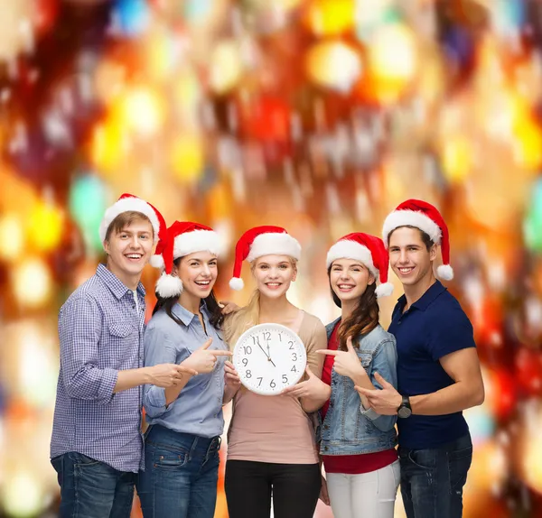 Grupo de estudiantes sonrientes con reloj mostrando 12 — Foto de Stock
