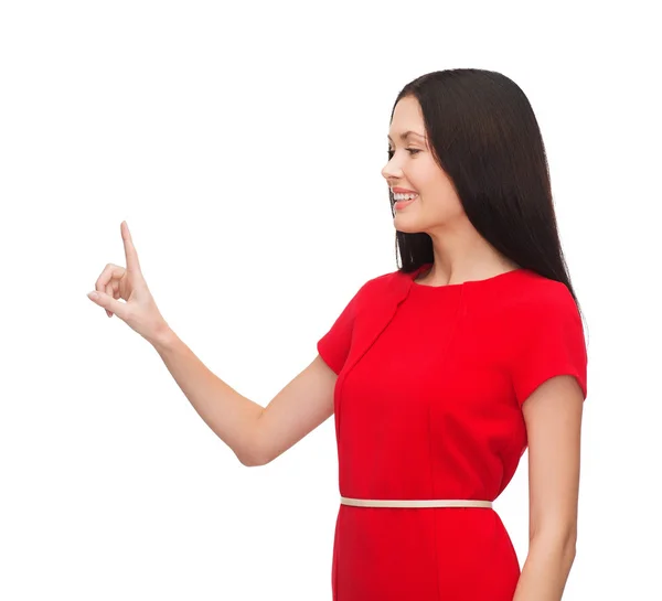 Parmağıyla işaret eden Kırmızı elbiseli genç kadın — Stok fotoğraf