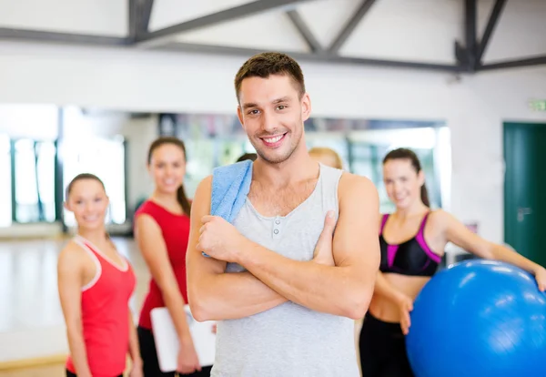 Glimlachende man die voor de groep in de sportschool — Stockfoto