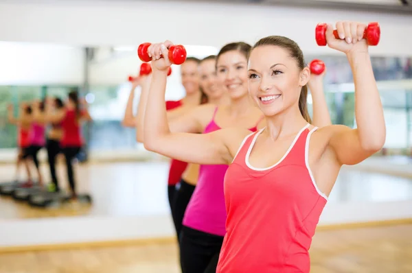 Group of smiling people working out with dumbbells — Stock Photo, Image