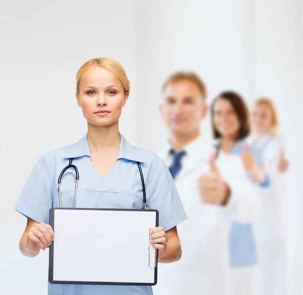 Улыбающаяся женщина-врач или медсестра с помощью доски — стоковое фото