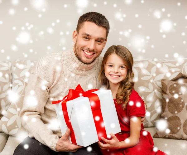 Leende far och dotter håller presentförpackning — Stockfoto