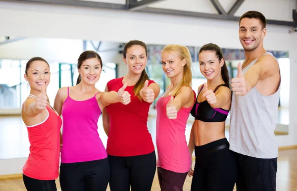 Groupe de personnes dans la salle de gym montrant pouces vers le haut — Photo