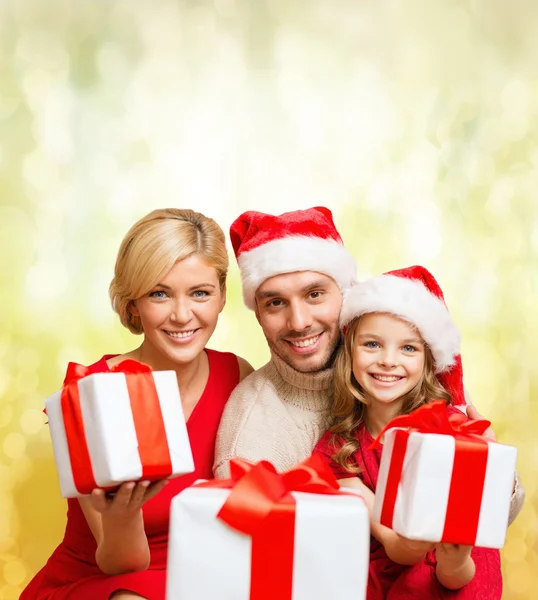 Smiling family giving many gift boxes — Stock Photo, Image