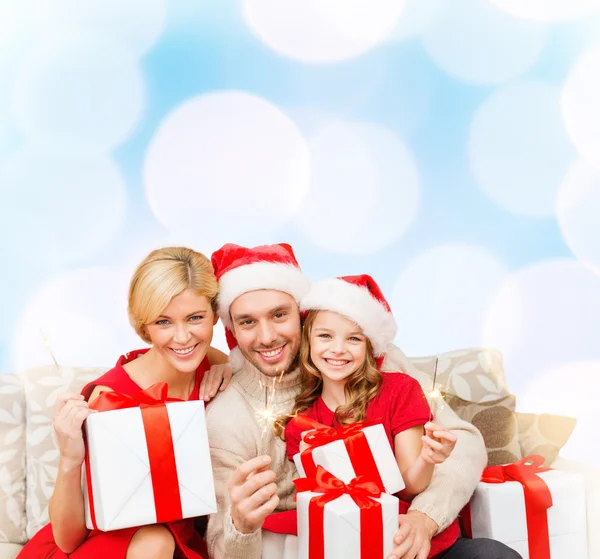 Famiglia sorridente che tiene scatole regalo e scintille — Foto Stock