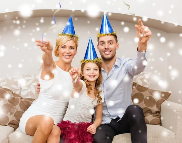 Familia feliz en sombreros azules lanzando serpentina —  Fotos de Stock