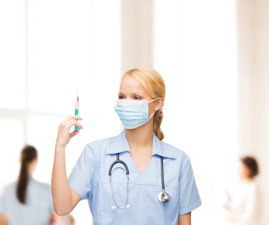 Female doctor or nurse in mask holding syringe clipart