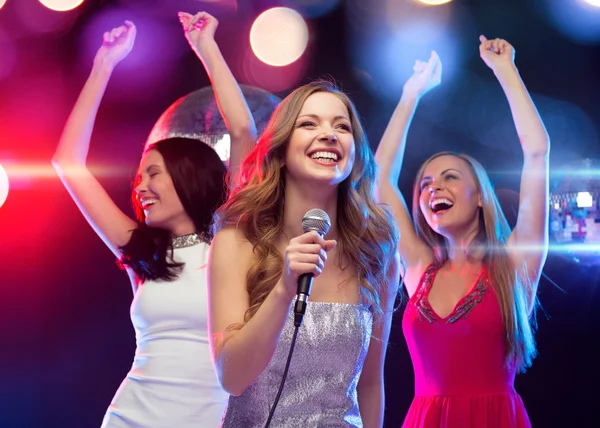 Tres mujeres sonrientes bailando y cantando karaoke —  Fotos de Stock