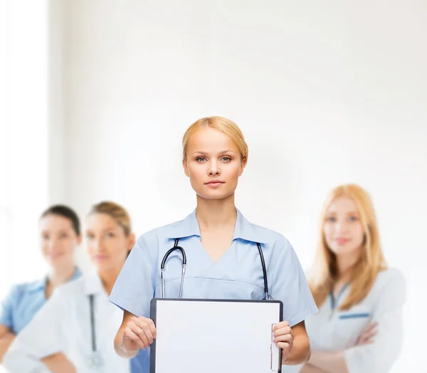 Smiling female doctor or nurse with sclipboard — Stock Photo, Image