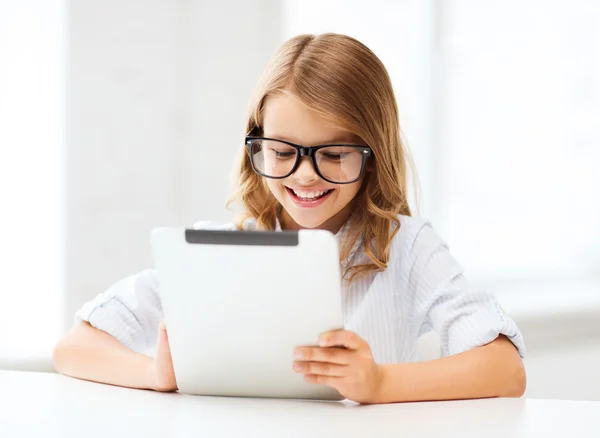 Lachende meisje in glazen met tablet pc op school — Stockfoto