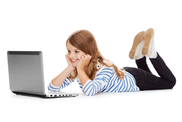 Menina estudante sorrindo com computador portátil deitado — Fotografia de Stock