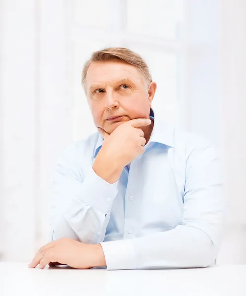 Stressed old man holding head at home — Stock Photo, Image