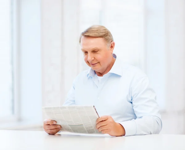 Velho em casa lendo jornal — Fotografia de Stock