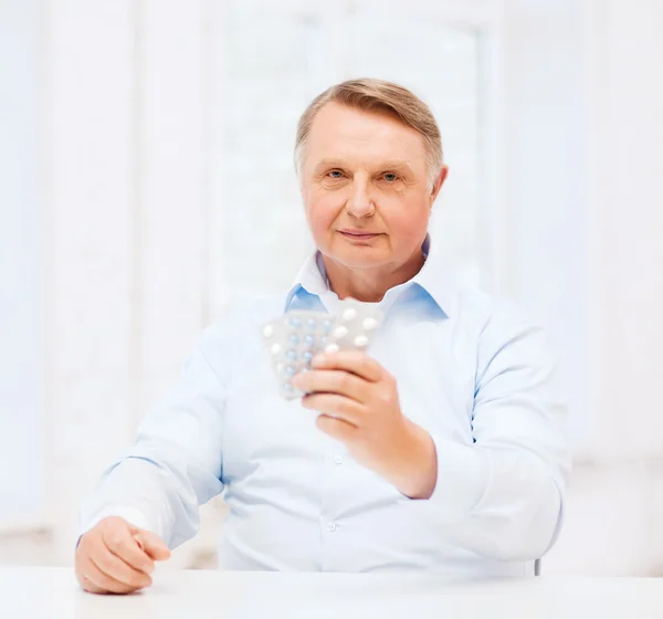 Old man with pack of pills — Stock Photo, Image