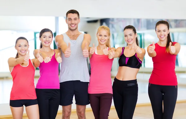 Grupp människor i gymmet visar tummen — Stockfoto