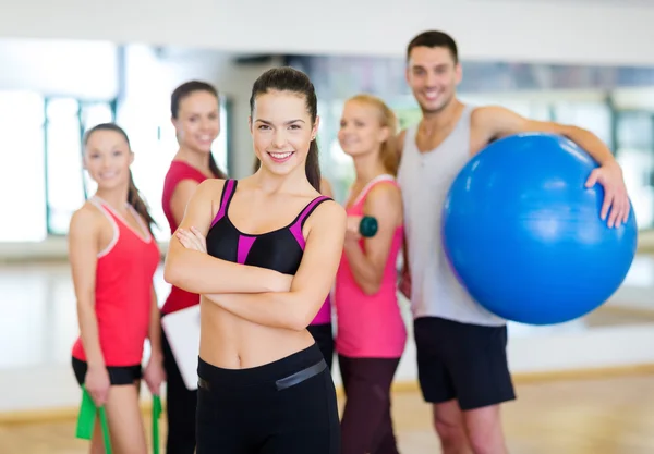 Donna in piedi davanti al gruppo in palestra — Foto Stock