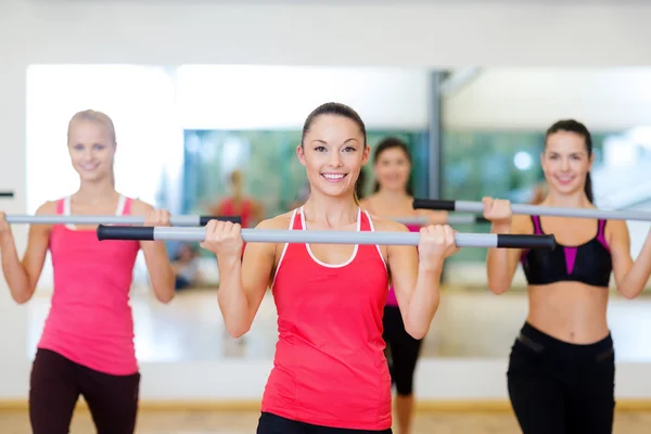 Grupo de personas sonrientes haciendo ejercicio con las barras —  Fotos de Stock