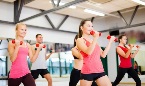 Grup gülümseyen insanların dumbell ile çalışma — Stok fotoğraf