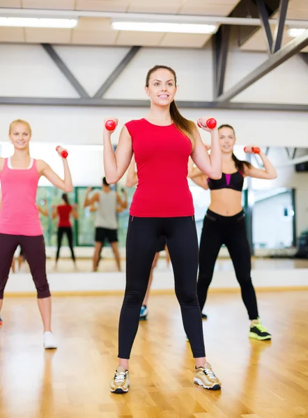 Group of smiling people working out with dumbbells — Stock Photo, Image