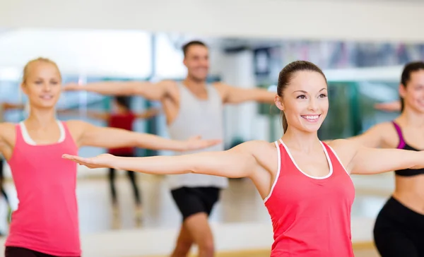 Group of smiling people exercising in the gym Stock Image