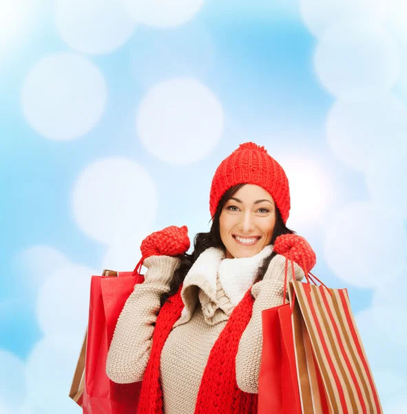 買い物袋で暖か着るべき服の女性の笑みを浮かべてください。 — ストック写真
