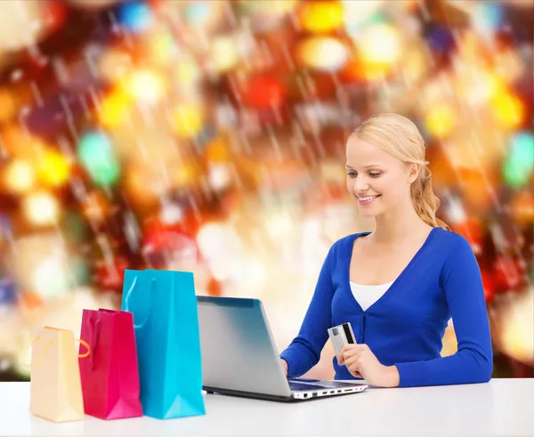 Dizüstü bilgisayar, alışveriş torbaları ve kredi kartı ile kadın — Stok fotoğraf