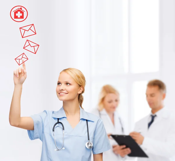 Médico sonriente o enfermera apuntando a un sobre — Foto de Stock