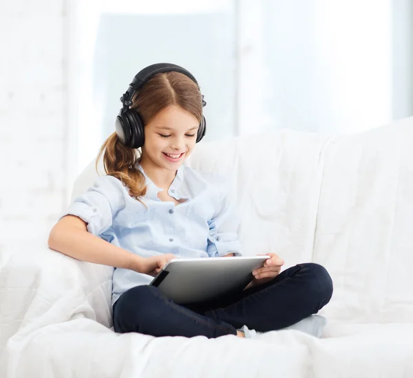 Ragazza con tablet pc e cuffie a casa — Foto Stock