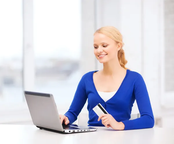 Mulher sorridente com computador portátil e cartão de crédito — Fotografia de Stock