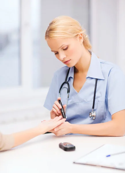 Medico o infermiere donna che misura il valore dello zucchero nel sangue — Foto Stock