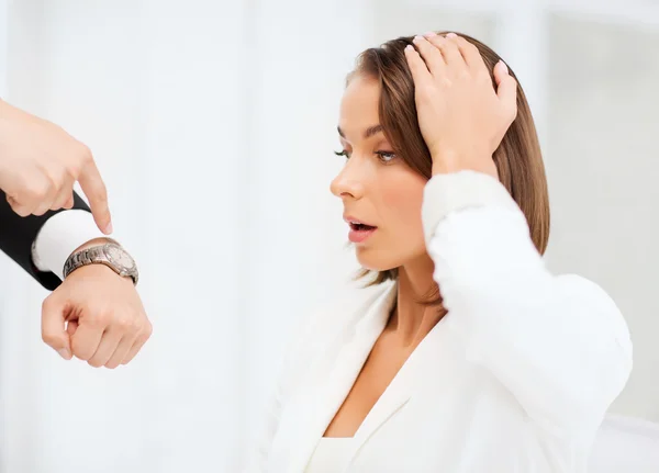 Chef zeigt gestresster Geschäftsfrau Zeit — Stockfoto