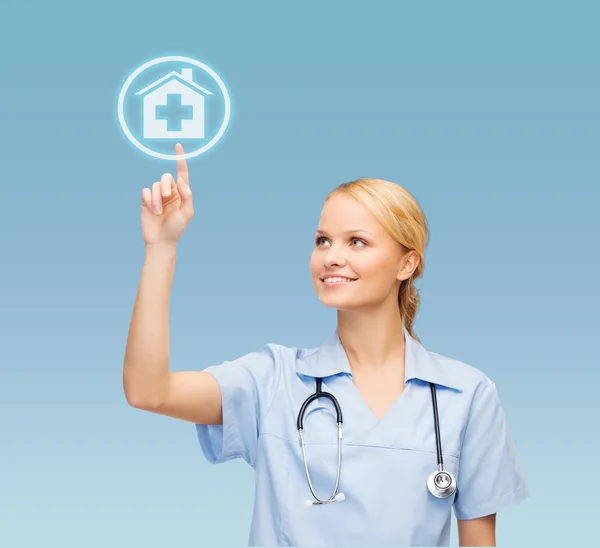 Lächelnder Arzt oder Krankenschwester zeigt auf Krankenhaus-Ikone — Stockfoto