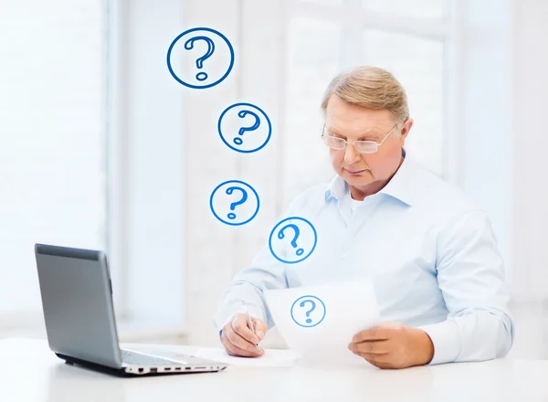 Old man in eyeglasses filling a form at home — Stock Photo, Image