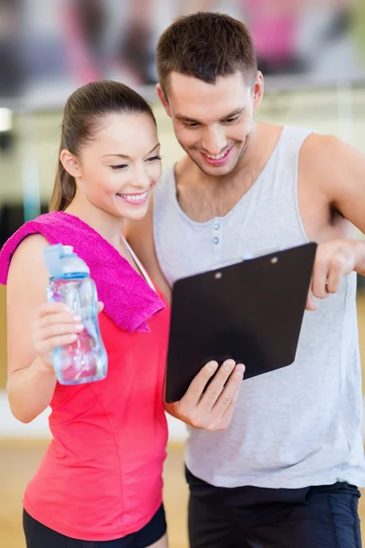 Smiling male trainer with woman in the gym Royalty Free Stock Photos