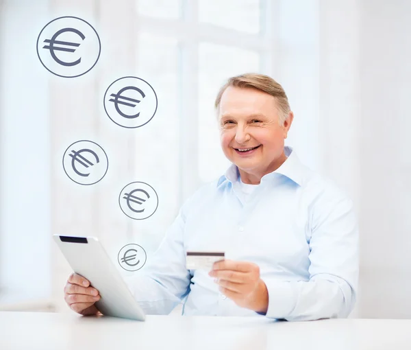 Old man with tablet pc and credit card at home — Stock Photo, Image