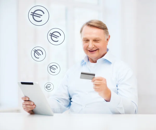 Old man with tablet pc and credit card at home — Stock Photo, Image