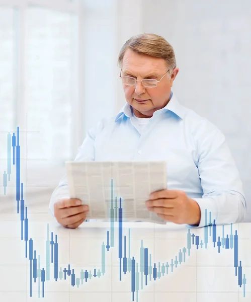 Old man at home with newspaper and forex chart — Stock Photo, Image