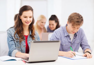Students with laptop and notebooks at school clipart