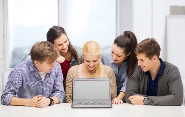 Estudantes sorrindo olhando para tela de lapotop em branco — Fotografia de Stock