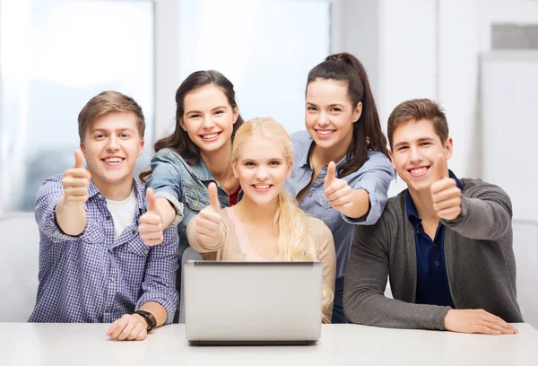 Étudiants souriants avec ordinateur portable montrant pouces vers le haut — Photo