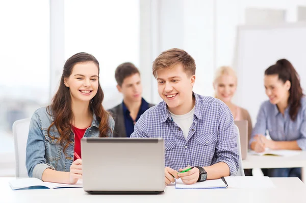 Estudantes com laptop e cadernos na escola — Fotografia de Stock