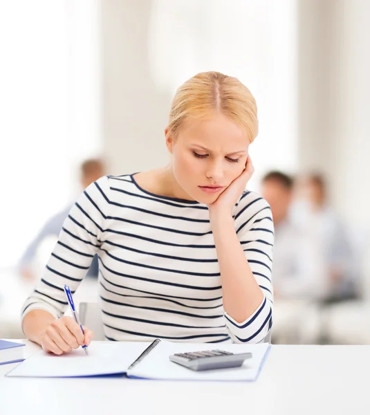 Mulher com caderno e calculadora estudando — Fotografia de Stock