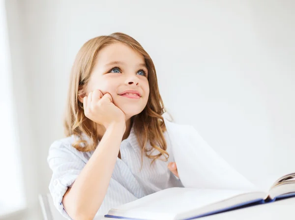 Student tjej skriver i anteckningsboken i skolan — Stockfoto