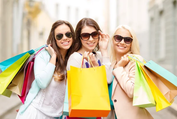 Three smiling girls with shopping bags in ctiy — Stock Photo, Image