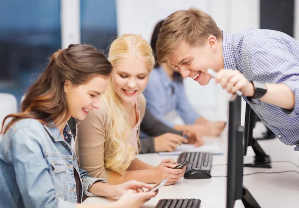 Estudiantes con monitor de computadora y smartphones — Foto de Stock