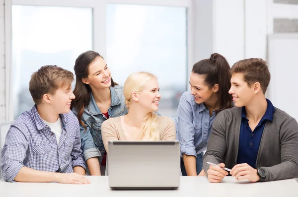 Smiling students with laptop at school — Stock Photo, Image
